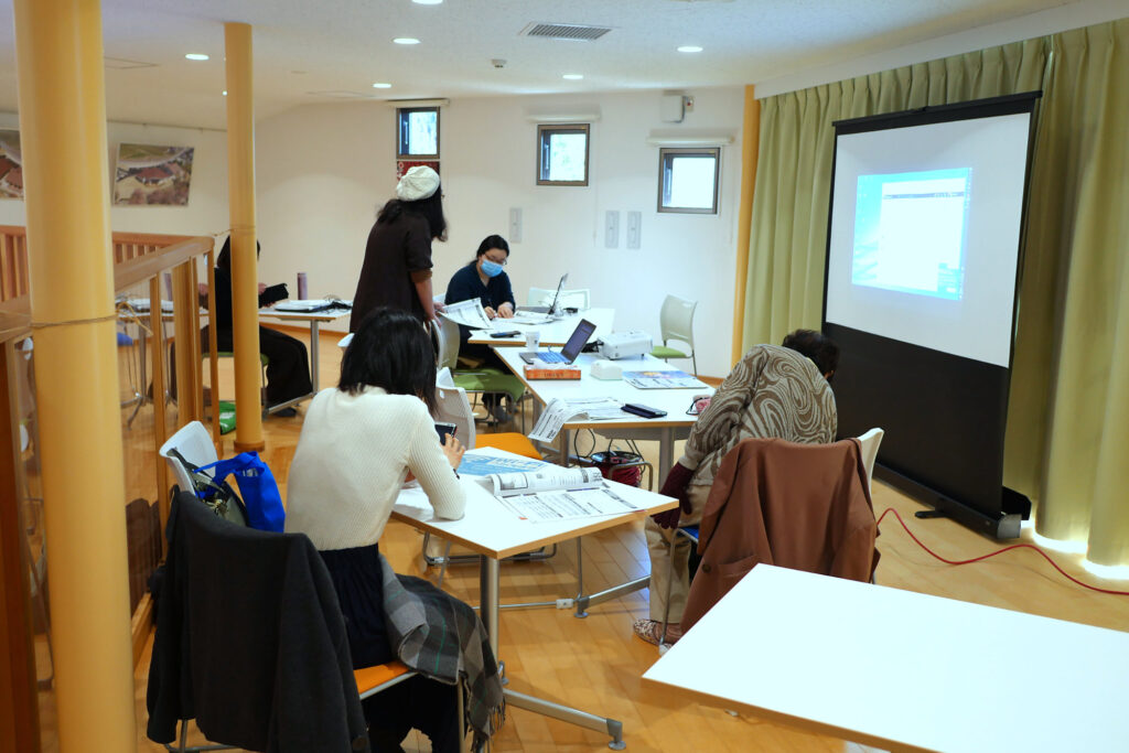 高森町 あったかてらす2F コワーキングスペースにて チームマネージャーの伊藤から子育てアプリ「ここいく」のCMS画面の操作方法の説明
